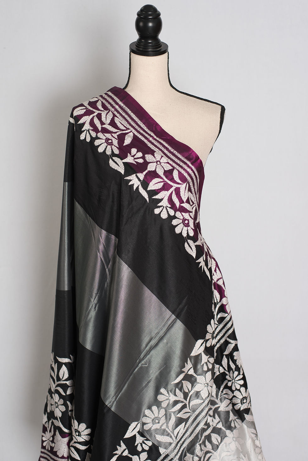 Thumbnail: Black and gray semi silk saree featuring hand-embroidered white Kantha stitch draped on a mannequin.