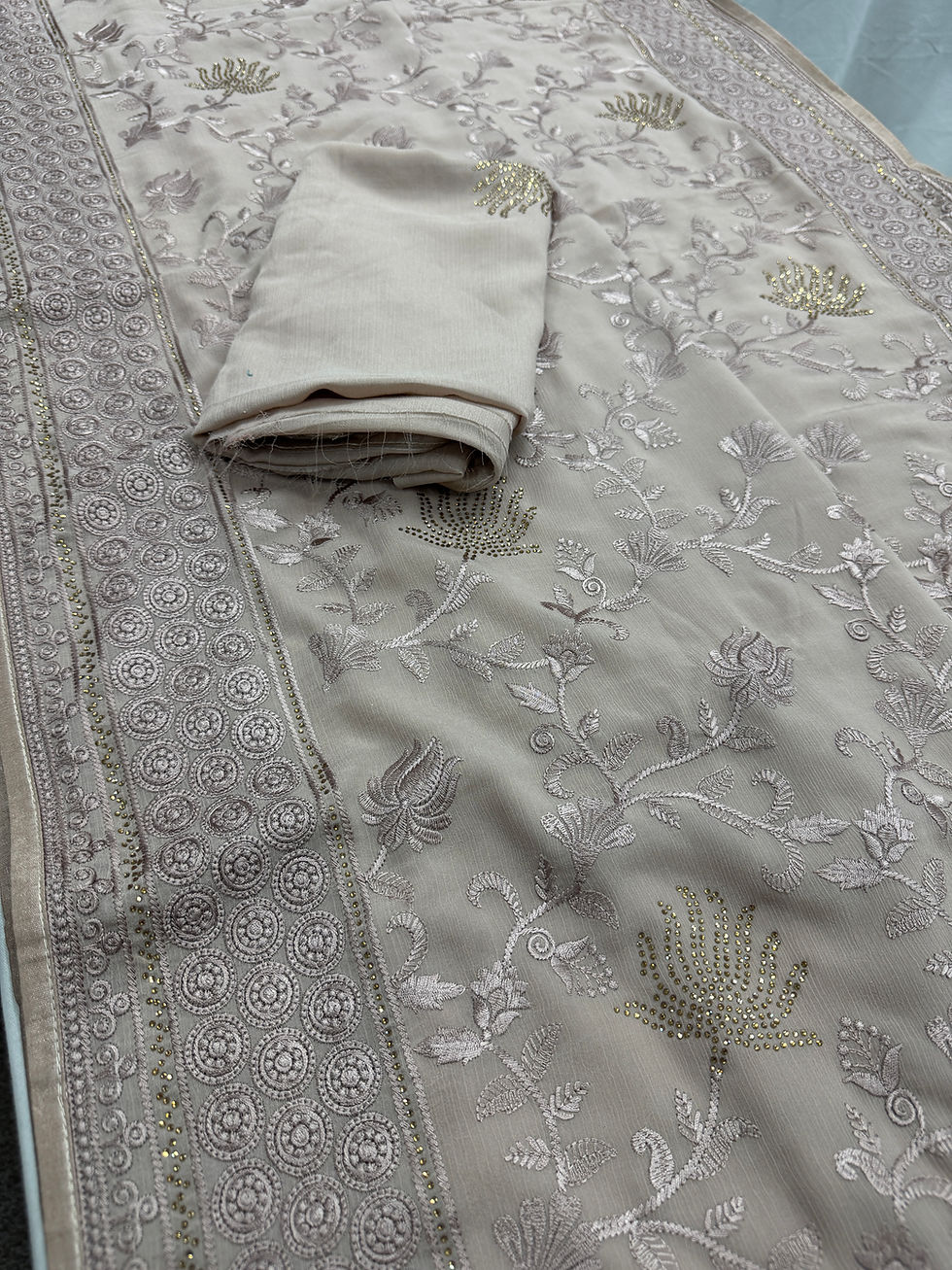 Thumbnail: Full body layout view of the pastel brown georgette partywear saree showing its rose-taupe fabric decorated with embroidery.