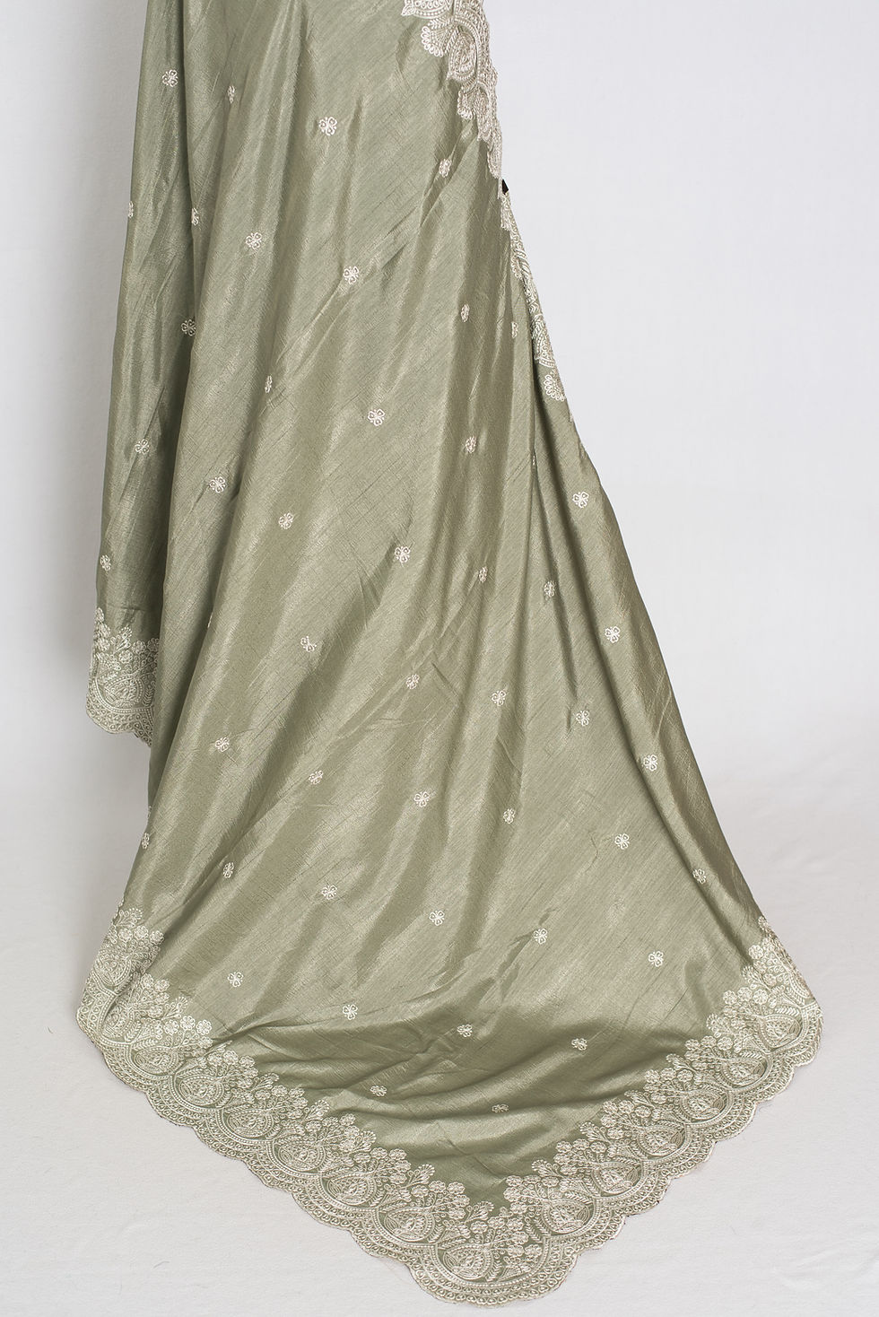 Thumbnail: sage green semi tussar silk saree on a mannequin displaying its fluid drape and detailed ivory embroidered scalloped borders.