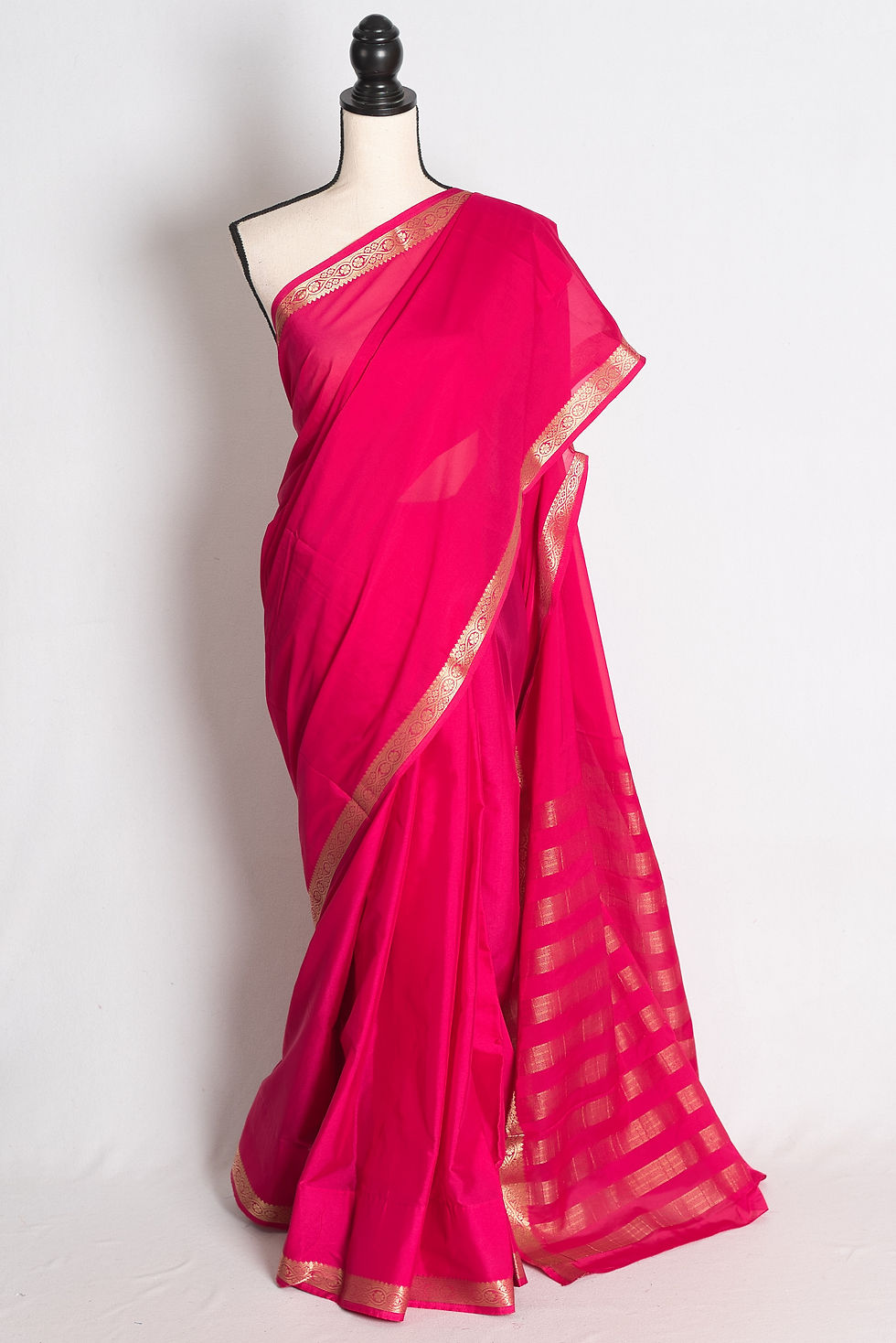 Dark Pink and Gold Semi Mysore Silk Saree draped elegantly on a mannequin showcasing its gold zari border and striped pallu.