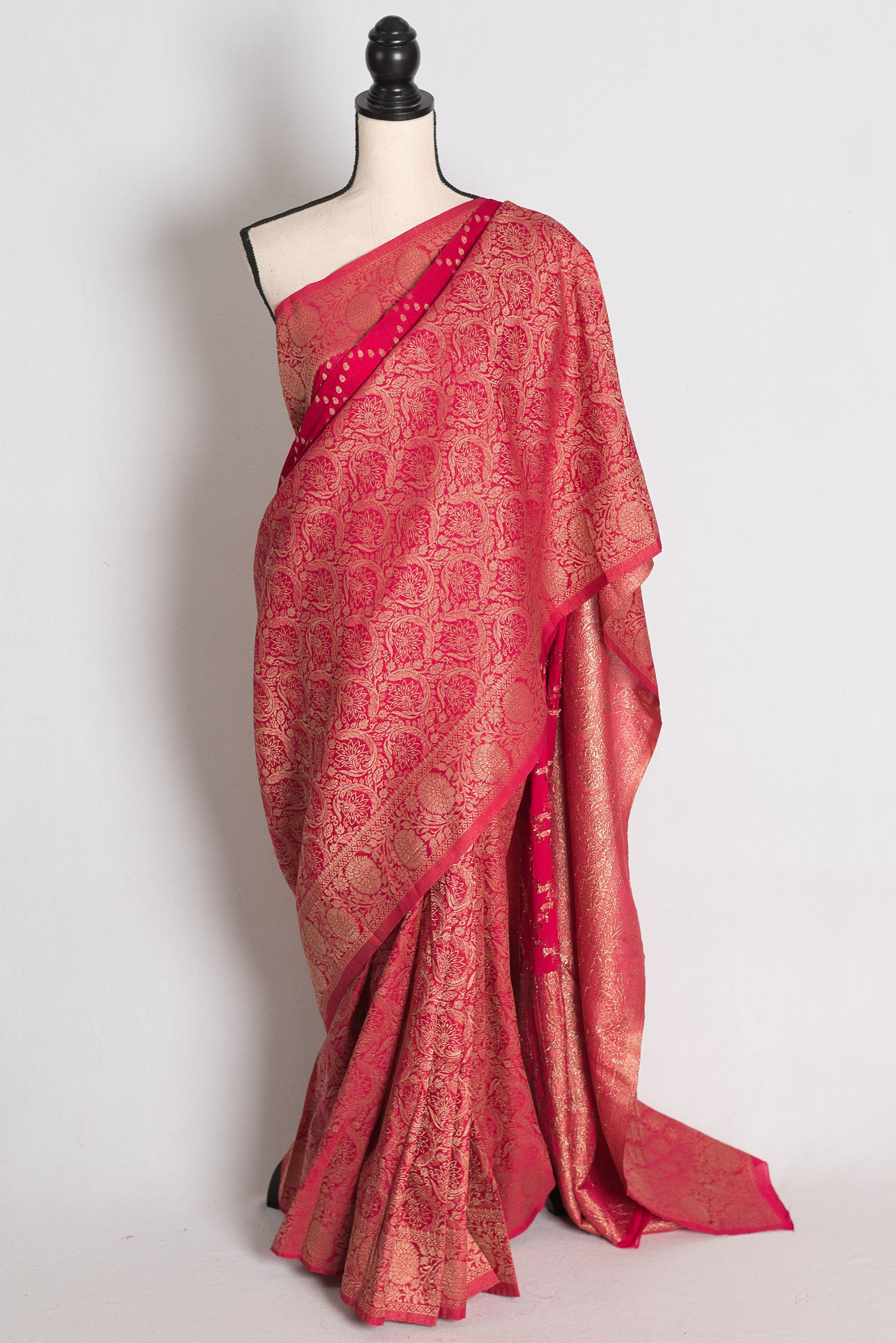 Rani Pink Semi Georgette Banarasi Saree draped elegantly on a mannequin showcasing its dramatic half skirt brocade border.
