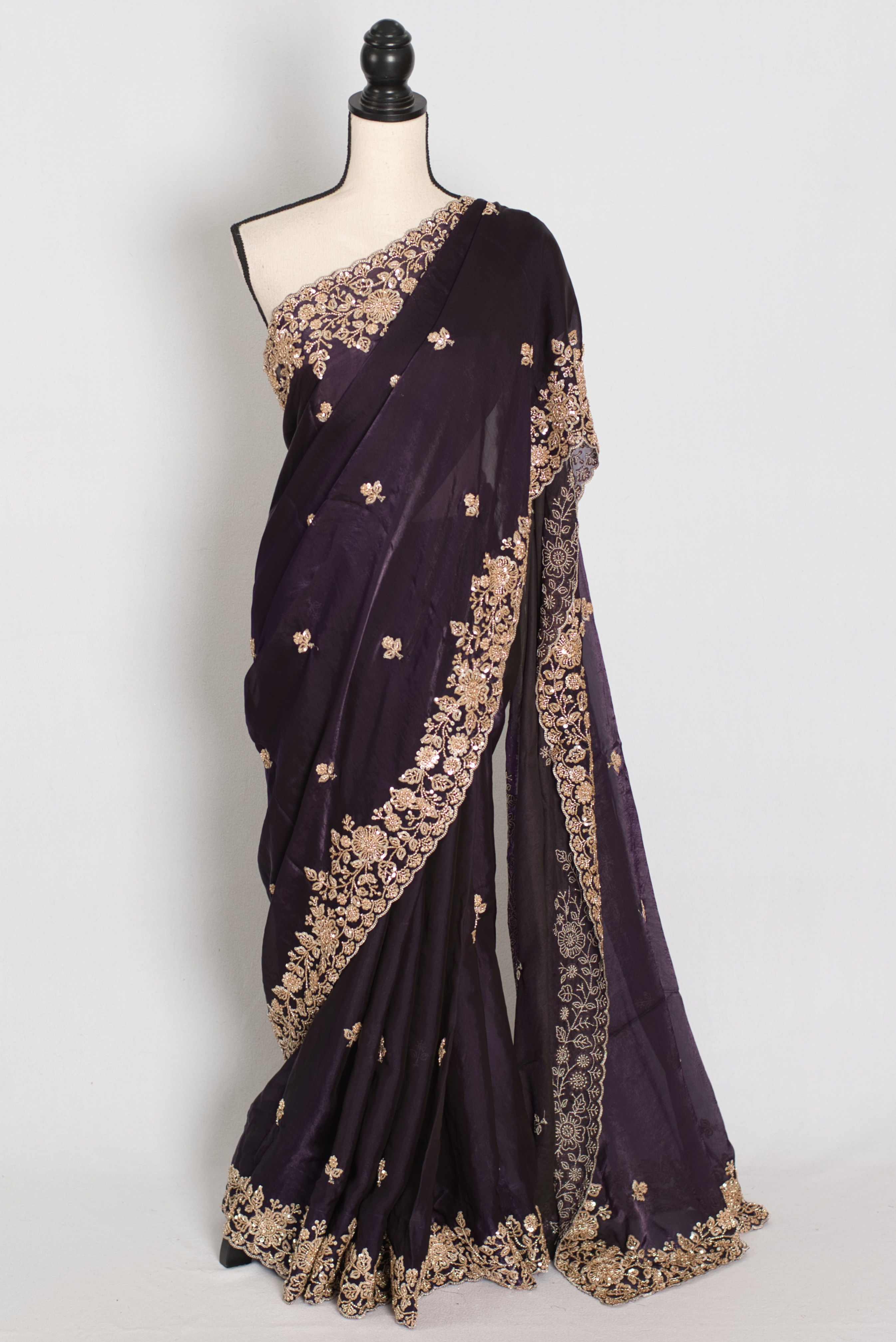 Front full-length view of the deep purple tissue zardosi embroidery saree draped on a mannequin.