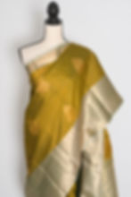 Thumbnail: Full length front view of the Harini olive green semi silk Kanjivaram saree with a wide contrast sage green gold zari border