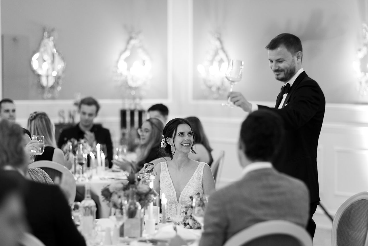 Herzensbild Hochzeitsfotografie einer freien Trauung im Strandhotel.  bräutigam spricht toast aus schwarzweiss