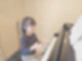 ピアノの前で拍子をとる女の子