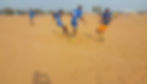 Eye-level view of a local football pitch in Gwanda with players warming up