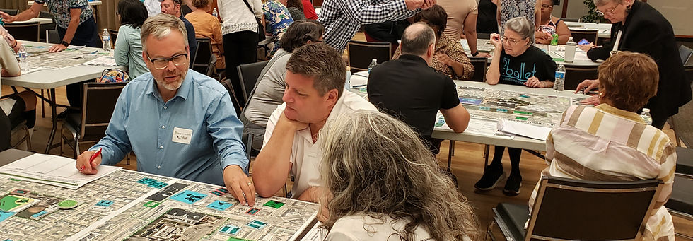 Kevin sits at a table with two others, working on a design exercise for the Shaker Recreation plan.