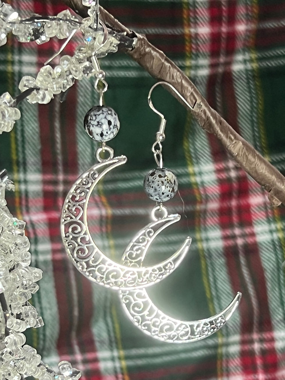 Elegant crescent moon earrings adorned with intricate filigree work and speckled stone bead accents.