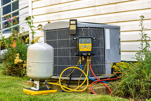 An old air conditioning unit that is being repaired by an HVAC service technician. The tec