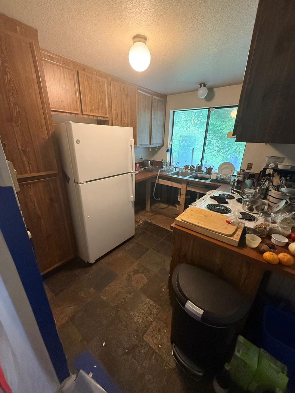 Before picture of a cramped, water-damaged kitchen in Olympia prior to an insurance restoration and full remodel by Fusion Builders