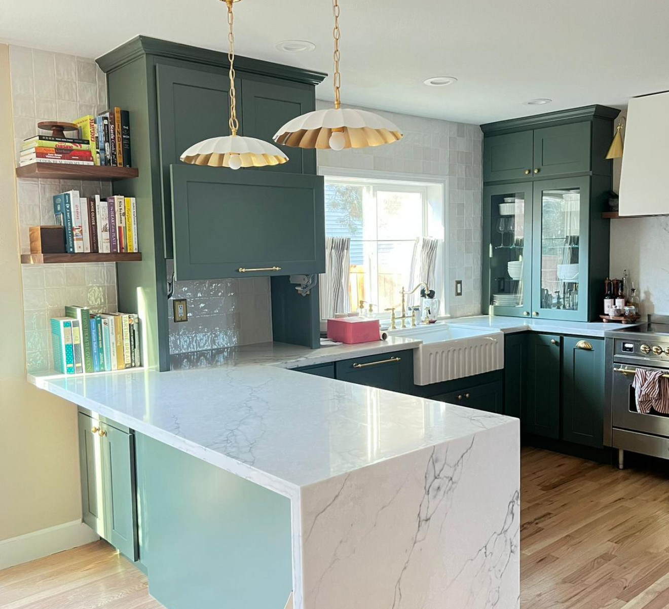 Modern open-concept kitchen remodel in Seattle featuring a custom white waterfall quartz island, premium cabinetry, and seamless hardwood floors.