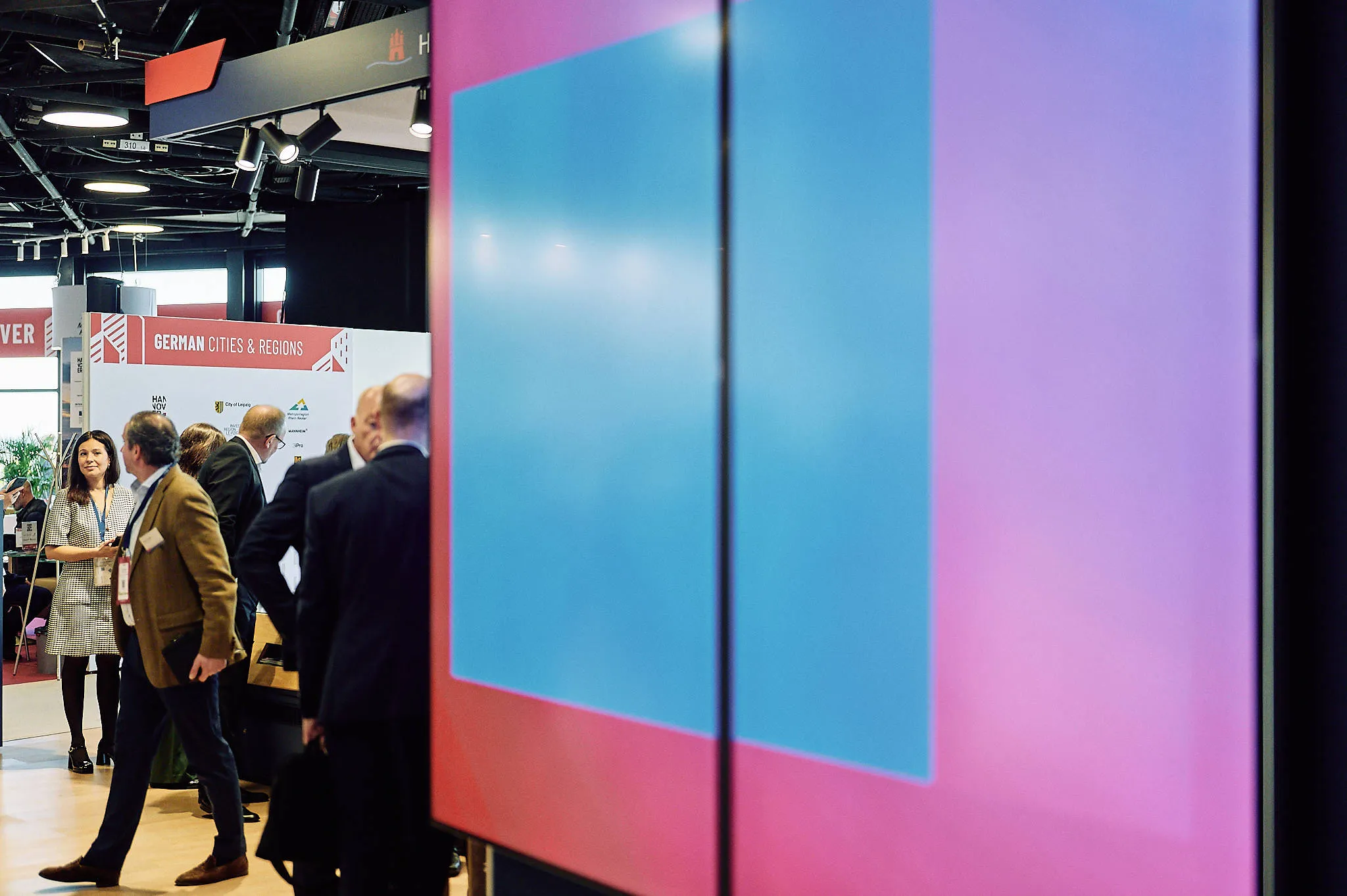 Large LED screen displaying vibrant motion graphics at an event.