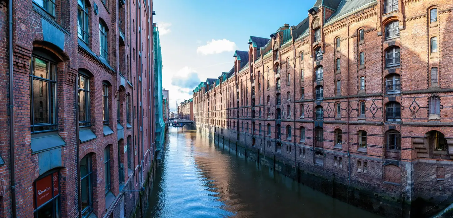 Blick in einen Wasserkanal der Hamburger Speicherstadt, flankiert von historischen Backsteinspeichern.