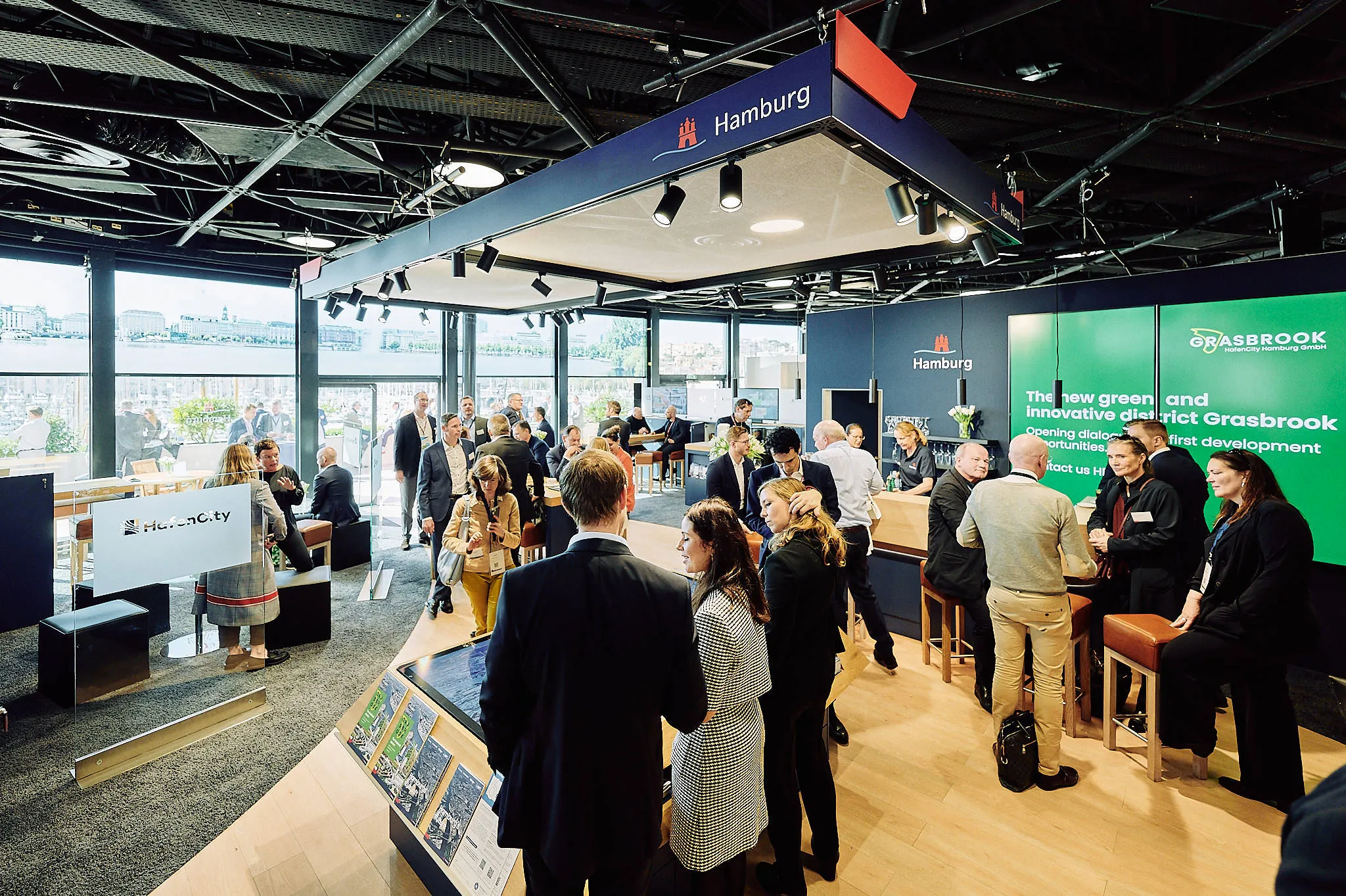 Crowded Hamburg exhibit booth at a professional event.