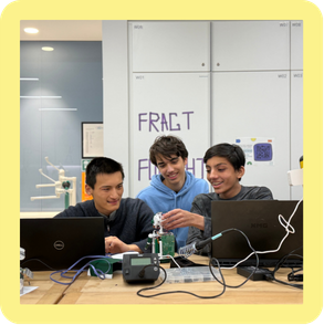 Drei Jugendliche arbeiten gemeinsam an einem Technikprojekt mit Laptops.