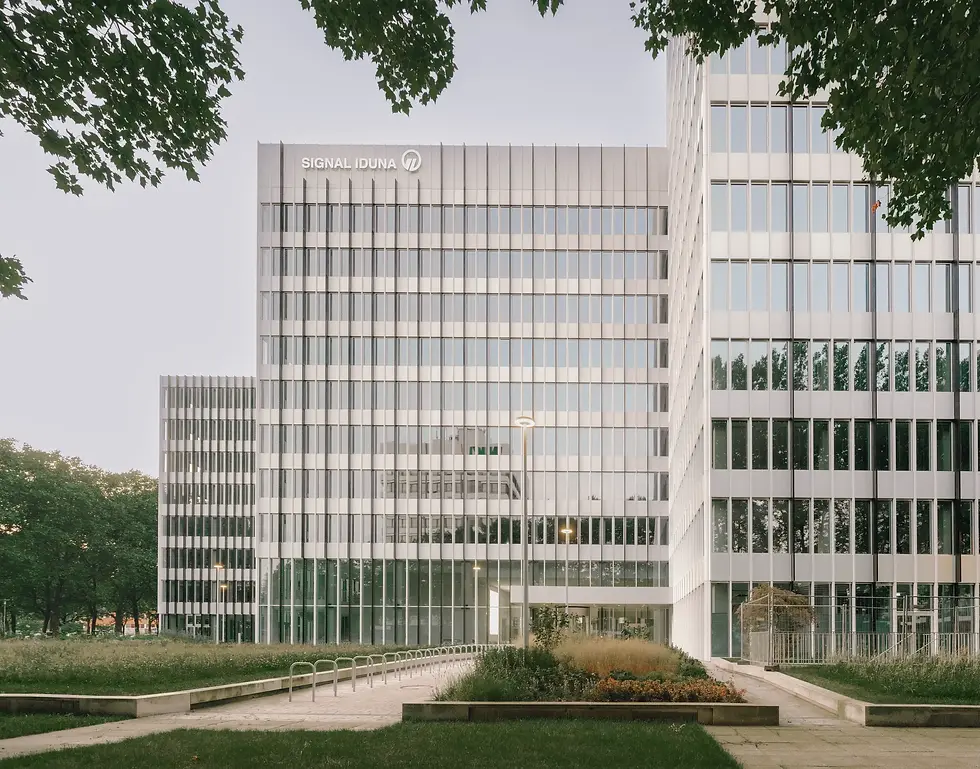 Außenansicht des Signal Iduna Gebäudes mit Glasfassade und Grünflächen im Vordergrund.