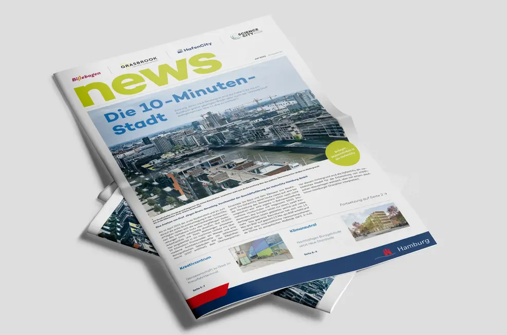 A printed newspaper with the headline "Die 10-Minuten-Stadt" and an aerial photo of HafenCity. 