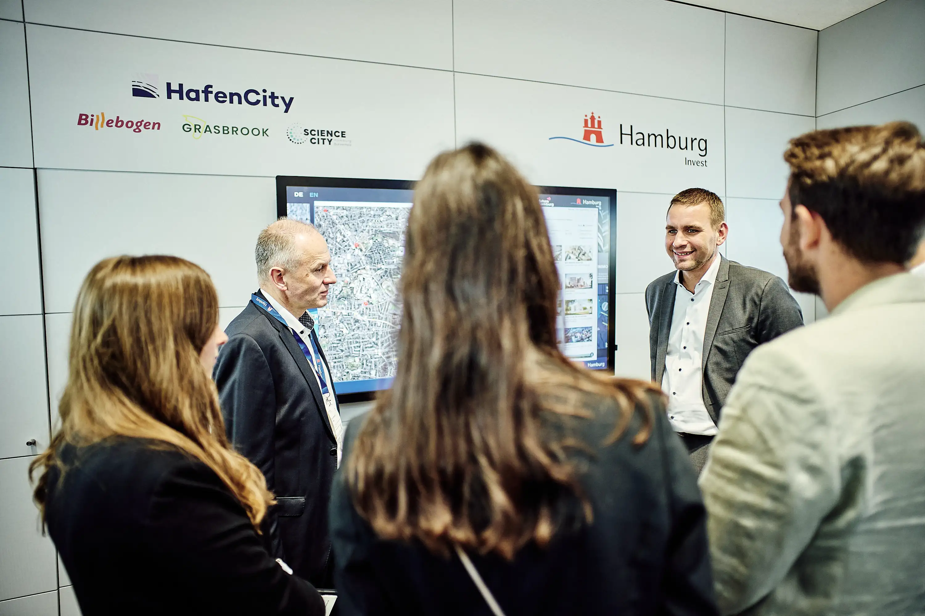 People viewing motion graphics at the EXPO REAL 2025 Hamburg booth.