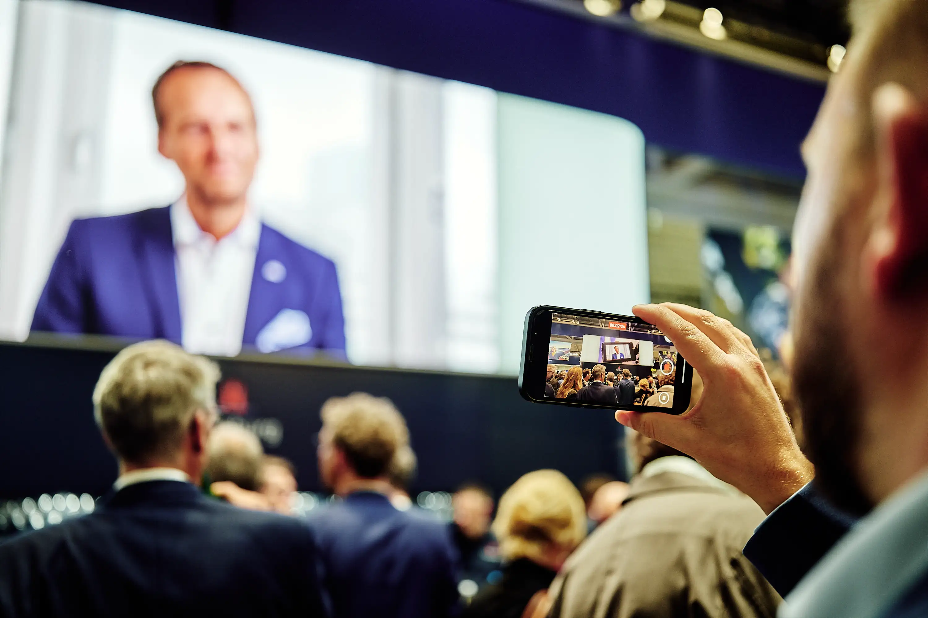 Motion graphics on screen at EXPO REAL 2025 event.