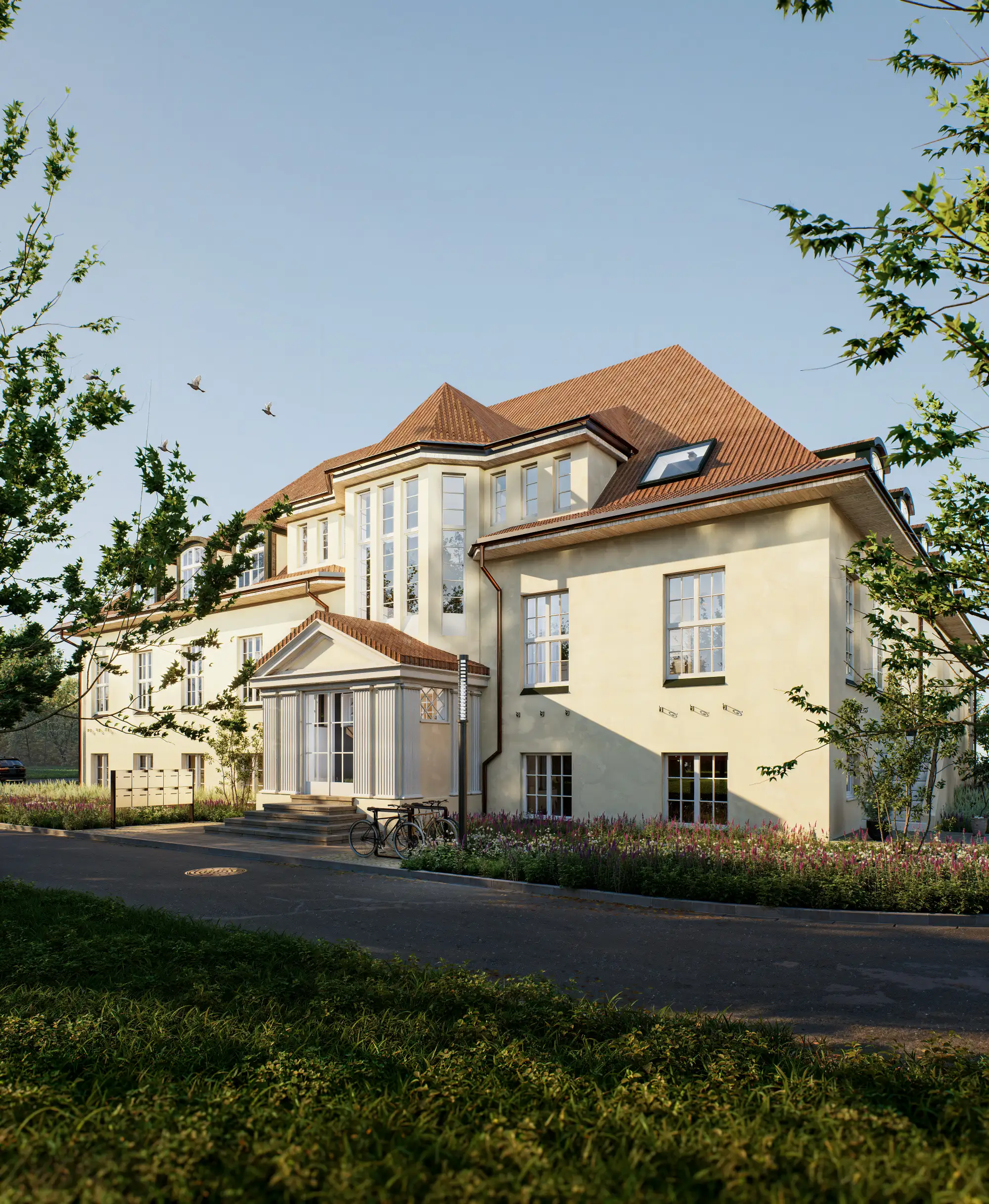 Grand entrance of a beige building with columned porch and flower beds.