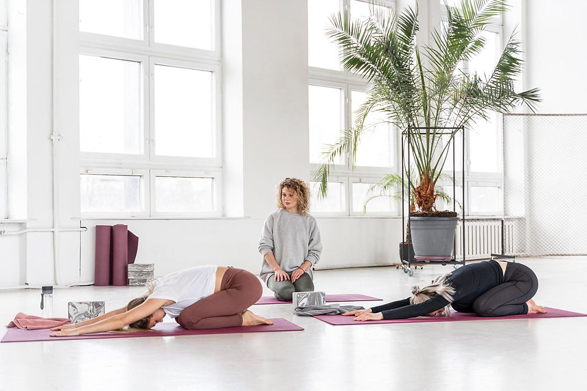 full-shot-teacher-watching-women-doing-yoga.jpg
