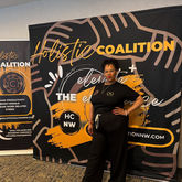 Woman standing in front of a Holistic Coalition backdrop.