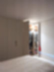 fully bespoke fitted half fluted doors with door open with integrated lighting, shelves and hanging space