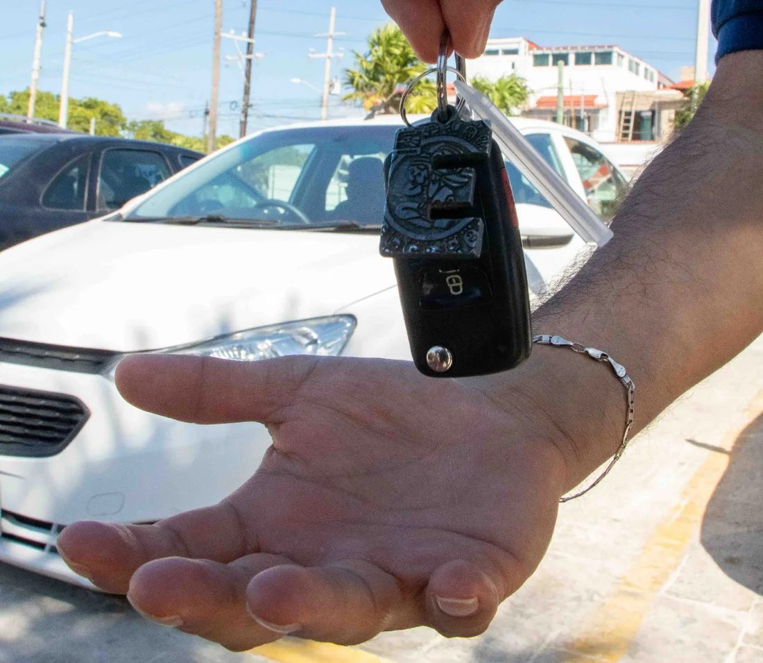 Turistas recibiendo llaves de auto rentado en Airbnb Cancún
