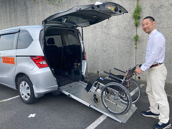 ドライバーが車いすを押して介護タクシーに乗せる様子