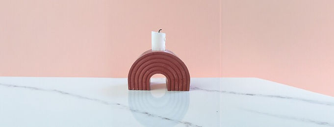 Porte-bougie arc-en-ciel couleur terracotta sur plateau en marbre