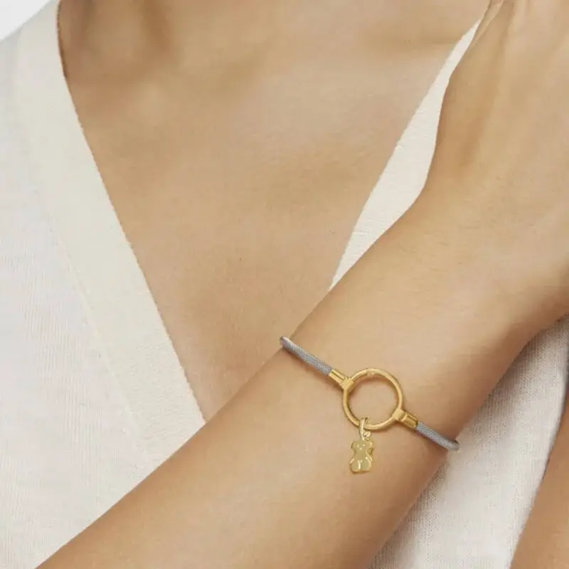 brazalete en acero plata con detalle dorado y figura de oso