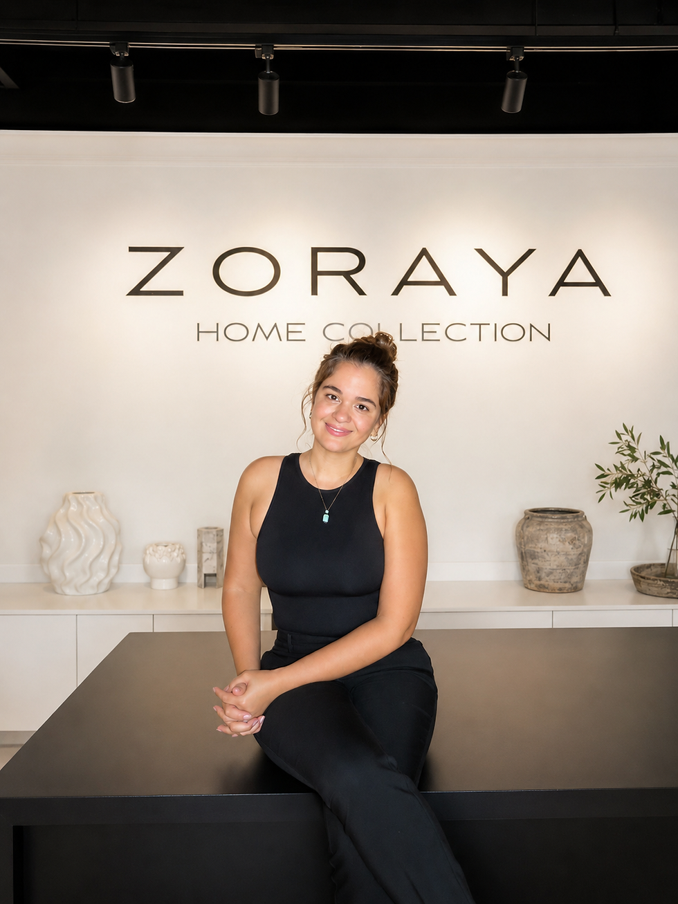 Woman sitting in front of the Zoraya Home Collection logo