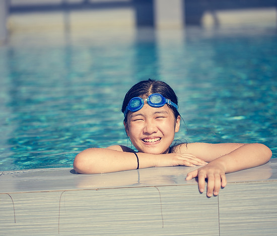 Happy girl swimming in pool