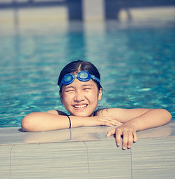 Natación feliz niña en la piscina