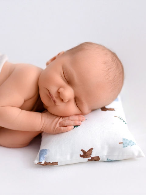 precious baby boy posed on a pillow sleeping