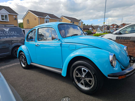 Blue classic Volkswagen Beetle side view after exterior detailing