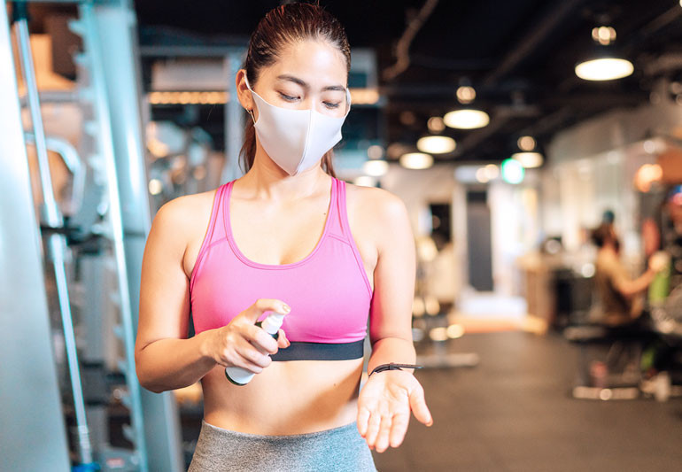 Woman wearing face mask which would not be required in her own garden gym room