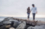 Two people walking on a beach.