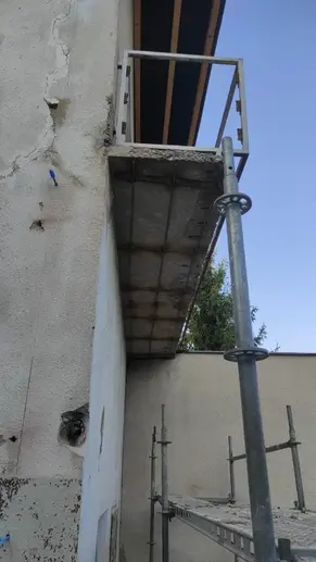 Spodná časť balkóna so starou železnou konštrukciou po odstránení omietky