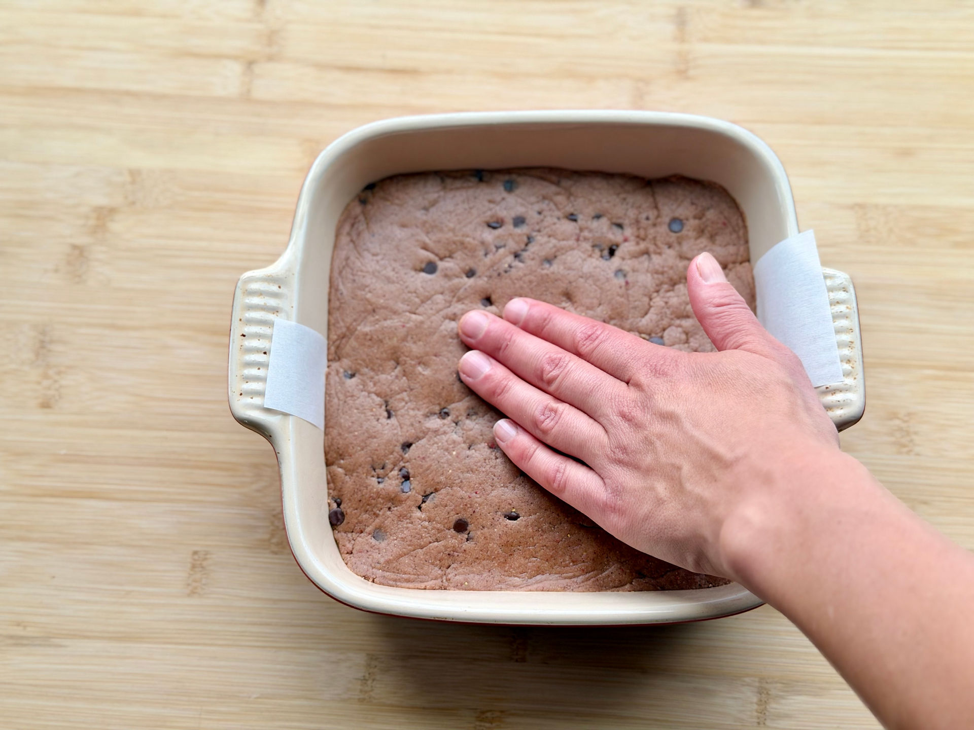 pressed No-Bake Chocolate Chip PB&J Protein Bar dough in an 8x8 pan