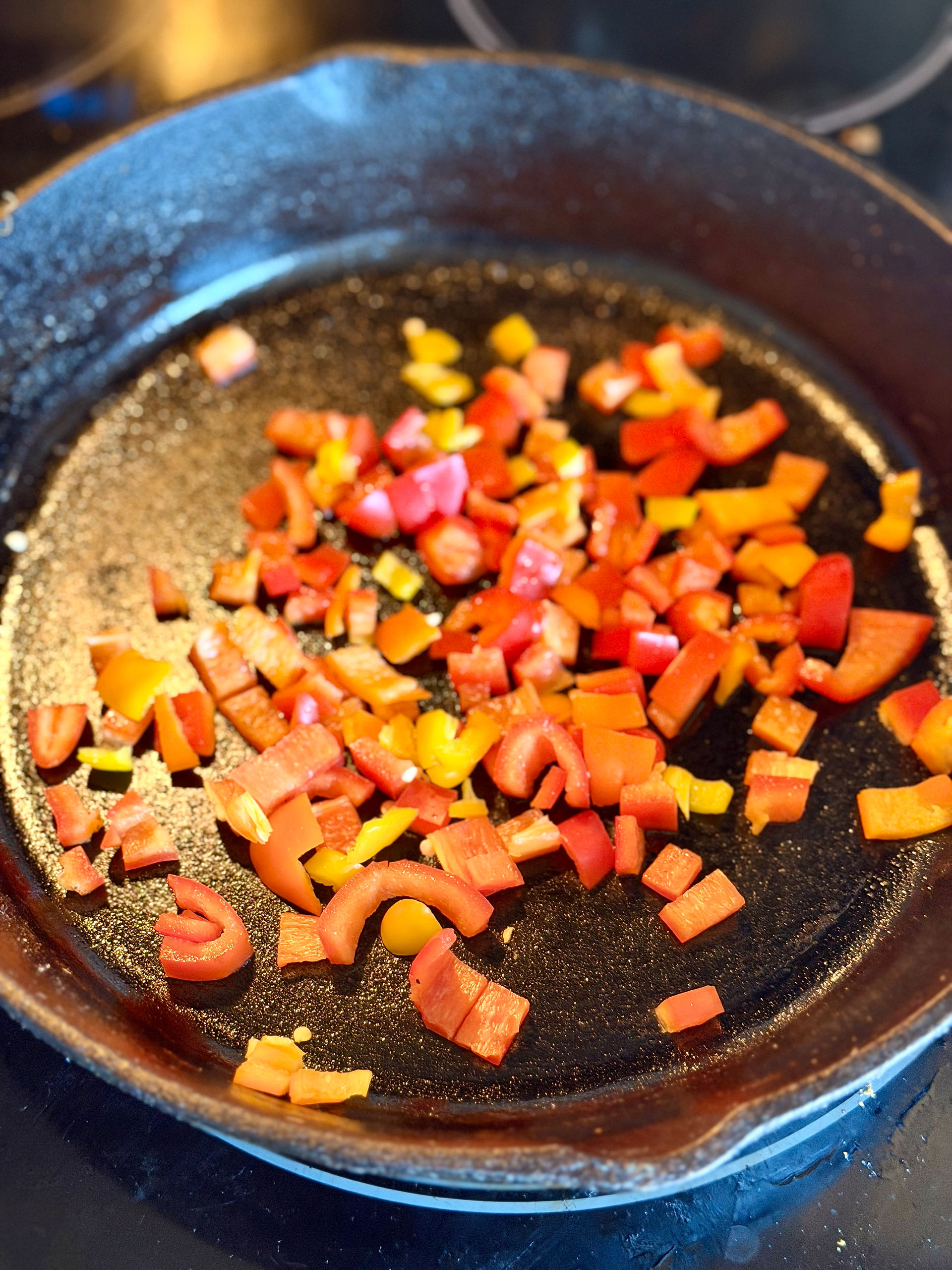red, yellow, and orange bell peppers in pan