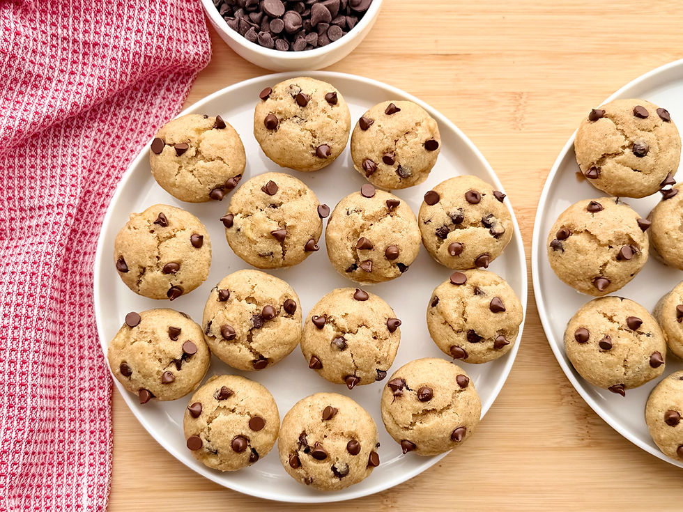 Gluten-Free Chocolate Banana Bread Mini Muffins on a plate next to a red dish towel and bowl of chocolate chips