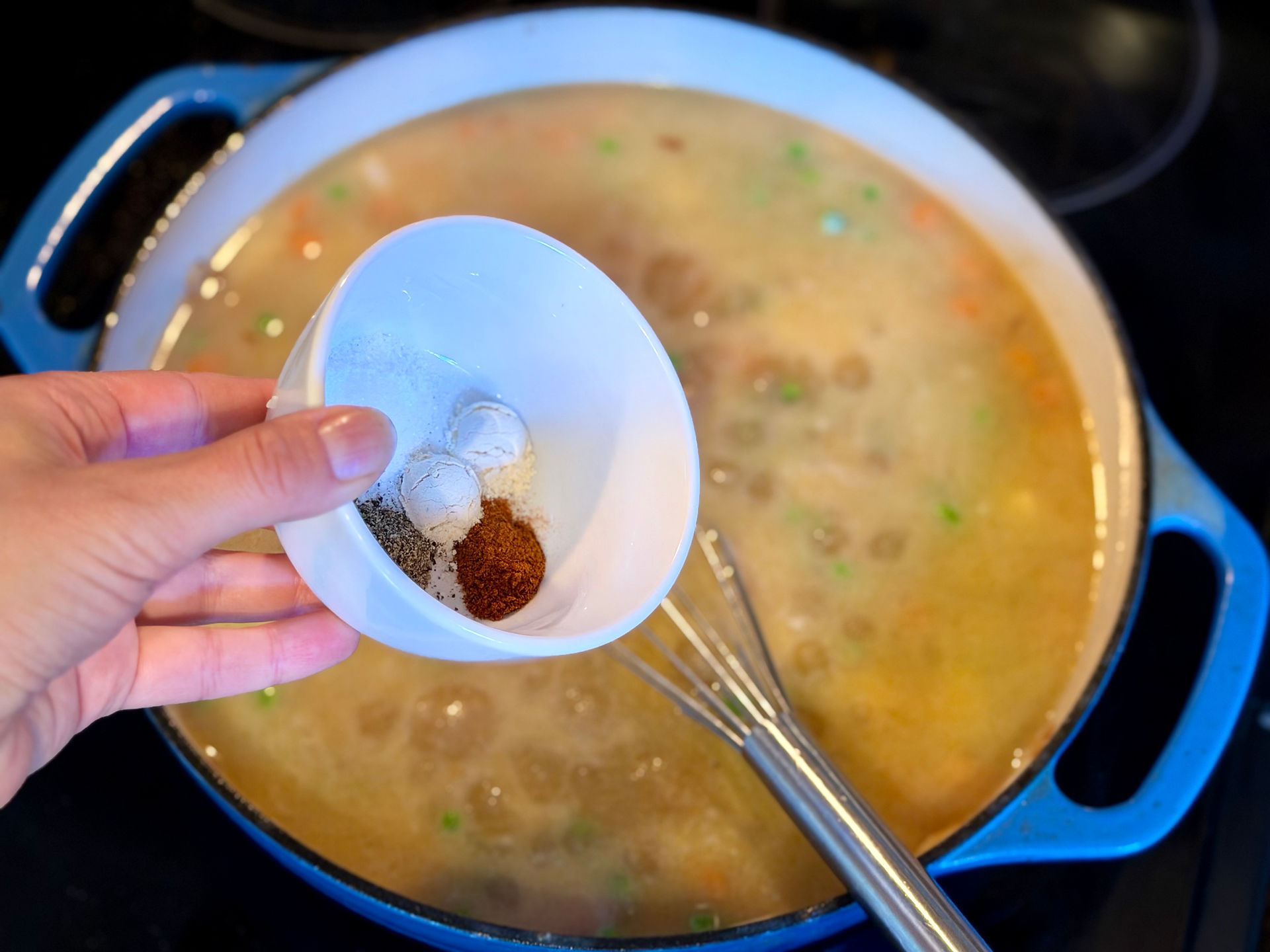 spices being added to roux and broth base for gluten free chicken pot pie