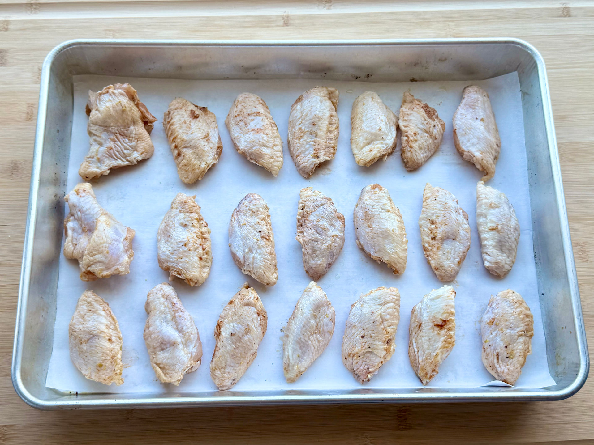 Chicken wings arranged on a baking sheet
