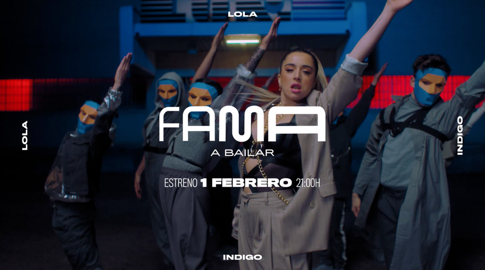 Lola Índigo y bailarines con máscaras bailan delante de la puerta de una discoteca.