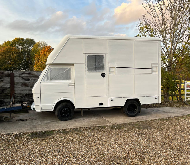 White high-top van on gravel driveway. Gwen had her first undercoat of painting.