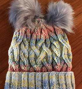 Nest Collection: cable-knit rainbow double pom pom hat.