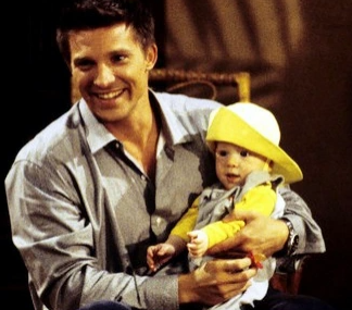 Jason Morgan smiles while holding a baby Michael Corinthos in a scene from General Hospital.