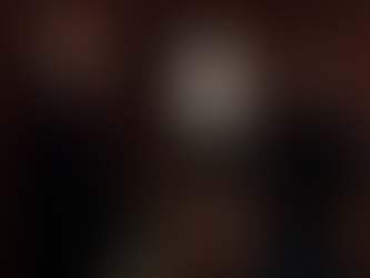 A tense confrontation between Jenz Sidwell and the man believed to be Nathan West, now revealed to be Cesar Faison, inside what appears to be a darkly decorated room with red walls and leather furniture. The two men stand face to face in a heated exchange.