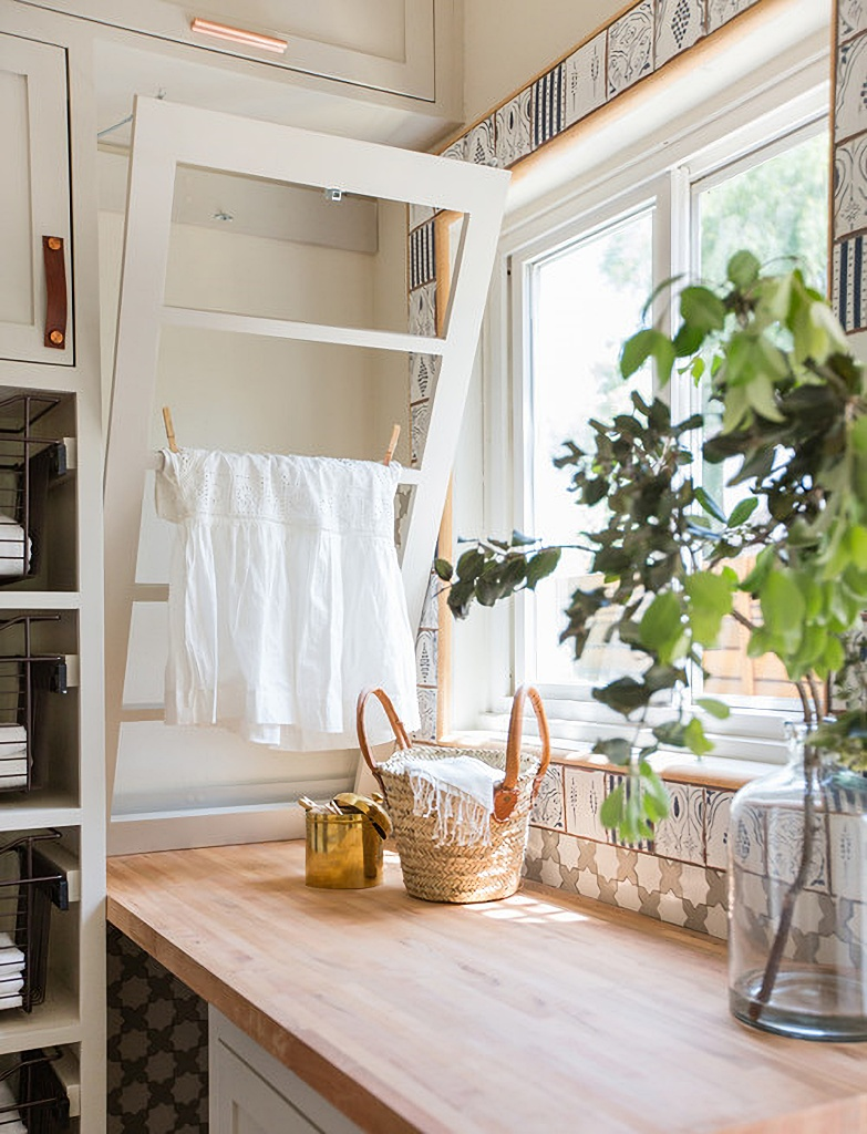 A cute laundry room with drying rack.